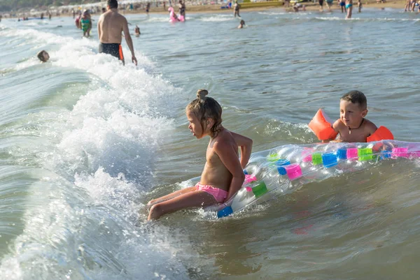 Felice stile di vita familiare. bambini che saltano e schizzano con divertimento nel rompere le onde. Fratello e sorella — Foto Stock