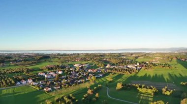 Yeşil tarlaları ve evleri olan güzel kırsal manzaralı bir yer.