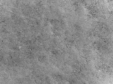 Bir sürü küçük kayanın olduğu gri bir yüzey. Yüzey pürüzsüz değil. Görünür bir çizgi ya da desen yok.