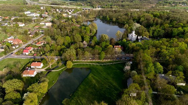 Arka planda bir göleti ve kilisesi olan güzel yeşil bir tarla. Sahne huzurlu ve huzurlu. Hava fotoğrafçılığı