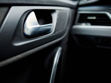 Arabanın kapısı açık ve içerisi karanlık. Kapı kolu gümüş, içi de siyah.