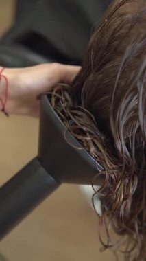 Kıvırcık kıvırcık saçlar. Bir tutam saç, nemlendirici kıvırcık saç. Bir kuaförün ellerinde kıvırcık saçlar. Kıvırcık kız yöntemi CGM