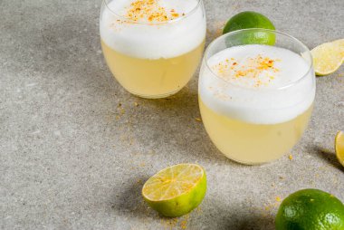 Peru, Meksika, Şili geleneksel içki pisco ekşi likör, kopya alanı gri taş masada taze limon ile