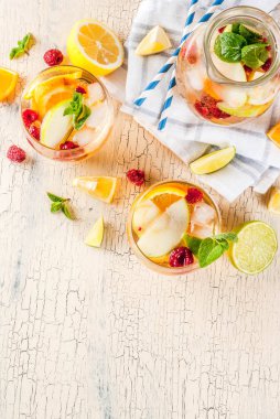 Yaz kokteyl, soğuk sangria elma, limon, portakal ve ahududu meyve ve meyve beyaz. hafif beton arka plan, kopya alanı Üstten Görünüm