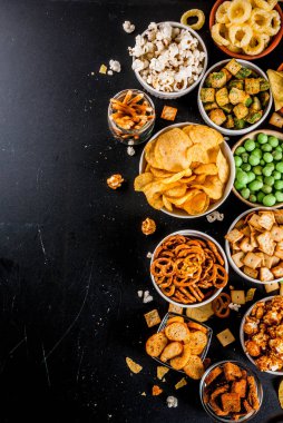 Varyasyon farklı sağlıksız atıştırmalıklar kraker, tatlı tuzlu popcorn, ekmeği, fındık, payet, bretsels, arka kara tahta kopya alanı