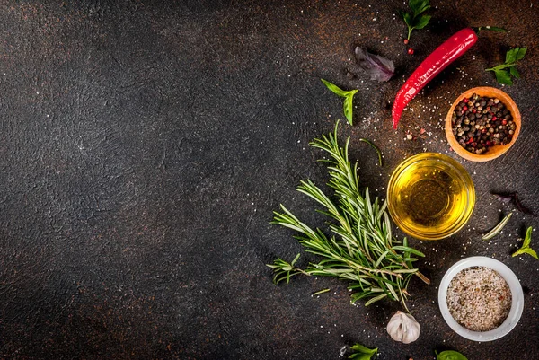 Cooking background, herbs, salt, spices, olive oil, dark rusty background copy space top view