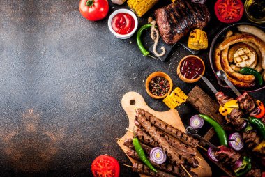 Çeşitler çeşitli barbekü yemek ızgara et, Barbekü partisi fest - şiş kebap, sosis, ızgara et fileto, taze sebze, sos, baharat, karanlık paslı beton, yukarıdaki tabloda kopya alanı