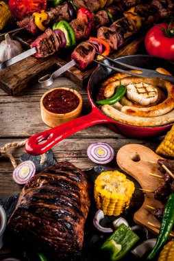 Çeşitler çeşitli barbekü yemek ızgara et, Barbekü partisi fest - şiş kebap, sosis, ızgara et fileto, taze sebze, soslar, baharatlar, kopya alanı yukarıda eski ahşap rustik masa üzerinde