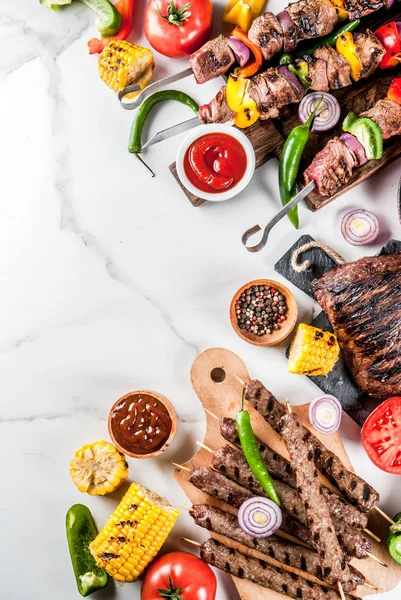 Çeşitler çeşitli barbekü yemek ızgara et, Barbekü partisi fest - şiş kebap, sosis, ızgara et fileto, taze sebze, sos, baharat, kopya alanı üzerinde beyaz mermer zemin