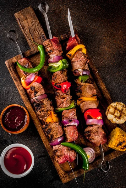 Taze, ev ızgara ateş et Dana şiş kebap sebze ve baharat Barbekü sos ve ketçap, ahşap kesme tahtası üzerinde kopya alanı üzerinde karanlık bir arka plan ile üzerinde yapımı