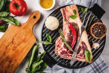 Ham sığır eti striplon kaburga eti baharat, ızgara tava ve otlar, beyaz mermer zemin üstten görünüm, kopya alanı ile mermer