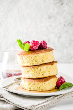 Trendy Asya gıda, kabarık Japonya sufle krep, hotcakes akçaağaç şurubu ve ahududu açık beton arka planı ile alanı Kopyala