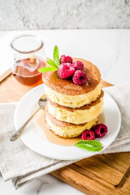 Trendy Asya gıda, kabarık Japonya sufle krep, hotcakes akçaağaç şurubu ve ahududu açık beton arka planı ile alanı Kopyala