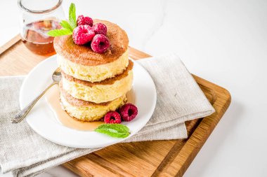 Trendy Asya gıda, kabarık Japonya sufle krep, hotcakes akçaağaç şurubu ve ahududu açık beton arka planı ile alanı Kopyala