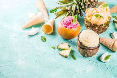 Yaz tatil tatil kavramı, ananas, greyfurt ve Hindistan cevizi çeşitli tropikal dondurma sorbets, donmuş suları ayarla, mavi beton arka plan kopya alanı ışık