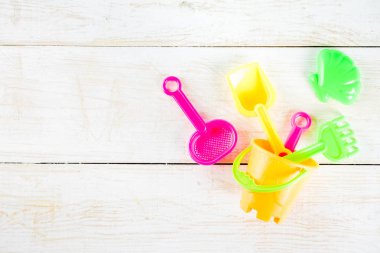 Yaz tatil kavramı ile plastik beach çocuklar oyuncak - kepçe, kepçe, Komisyon, kalıpları tekne, lifebuoy oyuncaklar alan beyaz ahşap arka plan yukarıdaki kopyalayın.