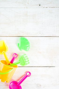 Yaz tatil kavramı ile plastik beach çocuklar oyuncak - kepçe, kepçe, Komisyon, kalıpları tekne, lifebuoy oyuncaklar alan beyaz ahşap arka plan yukarıdaki kopyalayın.