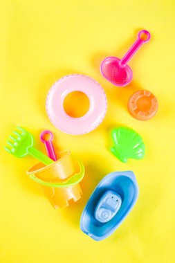 Yaz tatil kavramı ile plastik beach çocuklar oyuncak - kepçe, kepçe, Komisyon, kalıpları tekne, lifebuoy oyuncaklar alan sarı arka plan kopyalayın.
