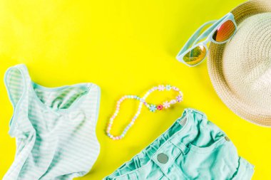 Yaz tatil kavramı, yaz çocuk bezi seti - çocuklar şort, tişört, şapka, güneş gözlüğü, bilezik kolye, spor ayakkabıları, parlak sarı arka plan düz yatıyordu kopya alanı üstüne