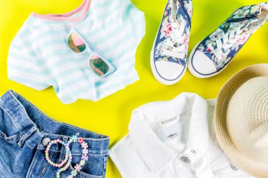 Yaz tatil kavramı, yaz çocuk bezi seti - çocuklar şort, tişört, şapka, güneş gözlüğü, bilezik kolye, spor ayakkabıları, parlak sarı arka plan düz yatıyordu kopya alanı üstüne