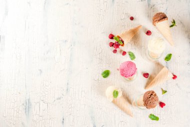 Yaz tatlı çilek ve tatlılar, çeşitli dondurma koni pembe (ahududu), vanilya ve çikolata nane hafif beton arka plan kopya alanı üstten görünüm ile lezzet