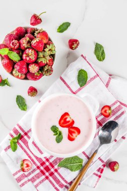 Tatlı kremalı çilek çorbası, vegan yaz yemeği, beyaz mermer arka plan fotokopi alanı.