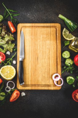 Yemek arka plan, taze salata malzemeleri, İtalyan mutfağı - Domates, zeytin yağı, limon, salatalık, roka, maydanoz, soğan, bıçak ve kesme tahtası, karanlık paslı arka plan kopya alanı üstten görünüm