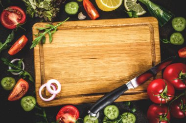 Yemek arka plan, taze salata malzemeleri, İtalyan mutfağı - Domates, zeytin yağı, limon, salatalık, roka, maydanoz, soğan, bıçak ve kesme tahtası, karanlık paslı arka plan kopya alanı üstten görünüm