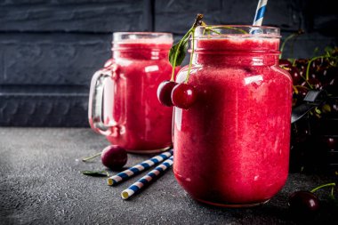 Yaz meyveli vitamin içeceği. koyu arka plan üzerinde ev yapımı kiraz smoothie
