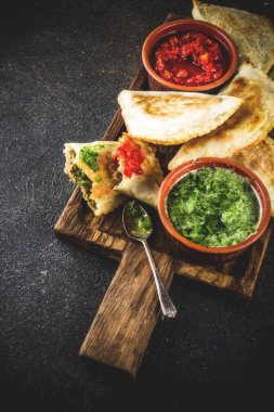 Latin Amerika, Meksika, Şili gıda. Geleneksel pişmiş pasta empanadas ile sığır eti, iki baharatlı soslar, karanlık paslı arka plan boşluk kopyalama