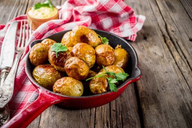 Fırında kızartma tavası bütün genç patates, ev yapımı Vejetaryen yiyecekler, eski ahşap rustik masa, soslu, kopyalama alanı