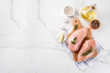 Çiğ et, tavuk göğsü fileto, zeytin yağı, otlar ve baharatlar beyaz mermer arka planda, kopya alanı Üstten Görünüm