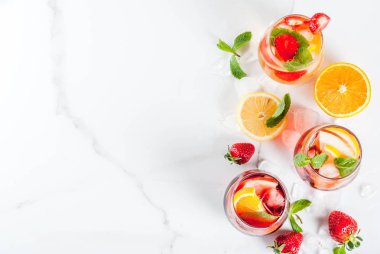 Taze meyveler, çilek ve nane ile soğuk beyaz, pembe ve kırmızı sangria kokteyller.