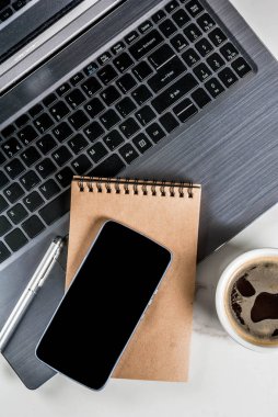 Çalışma alanı, beyaz Resepsiyon Masa laptop, smartphone, kahve fincanı ve Not Defteri ile Top kopya alanı görünümüyle