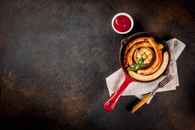 Ev yapımı ızgara biftek ve ketçap, koyu arka plan kopya alanı yukarıdaki ile kırmızı dökme demir tavada tavuk sosis