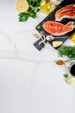Biftek ile limon, otlar, zeytin yağı, ızgara, kayrak kesme tahtası, beyaz mermer zemin kopya alanı yukarıdaki için hazır çiğ Somon Balık
