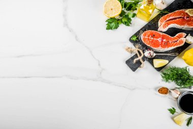 Biftek ile limon, otlar, zeytin yağı, ızgara, kayrak kesme tahtası, beyaz mermer zemin kopya alanı yukarıdaki için hazır çiğ Somon Balık