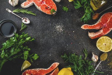 Çiğ Somon Balık biftek ile limon, otlar, zeytin yağı, ızgara, kayrak kesme tahtası, karanlık paslı arka plan kopya alanı için hazır