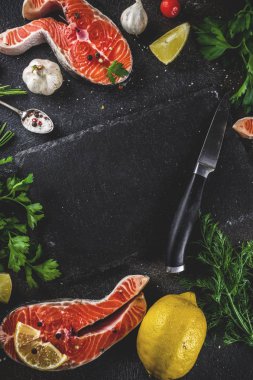 Çiğ Somon Balık biftek ile limon, otlar, zeytin yağı, ızgara, kayrak kesme tahtası, karanlık paslı arka plan kopya alanı için hazır