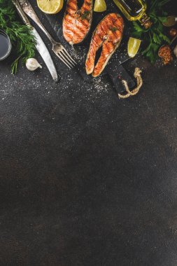 Izgara Somon Balık biftek malzemeler limon, otlar, zeytin yağı, kayrak kesme tahtası, karanlık paslı arka plan kopya alanı ile