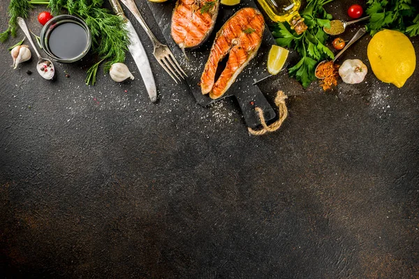 烤鲑鱼牛排配配料柠檬 橄榄油 石板切割板 深色生锈背景复制空间 — 图库照片