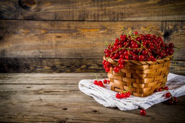 Küçük sepet, rustik ahşap masa kopya alanı içinde kırmızı kuş üzümü