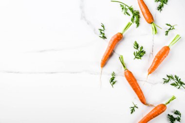 Yeşil yaprakları, beyaz mermer arka plan ile taze çiğ havuç alan en iyi görünüm Kopyala