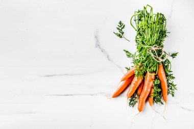 Yeşil yaprakları, beyaz mermer arka plan ile taze çiğ havuç alan en iyi görünüm Kopyala