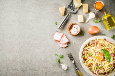 Geleneksel İtalyan Makarna, spagetti carbonara pastırma, krem sos, parmesan peyniri, yumurta sarısı ve taze fesleğen yaprakları gri taş arka plan kopya alanı