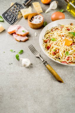 Geleneksel İtalyan Makarna, spagetti carbonara pastırma, krem sos, parmesan peyniri, yumurta sarısı ve taze fesleğen yaprakları gri taş arka plan kopya alanı