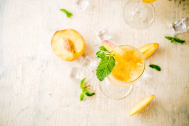 Yaz soğuk alkol içecek, buzlu Şeftali Bellini ile nane kokteyli bırakır, hafif beton arka plan kopya alanı