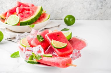 Dilimli karpuz ve nane, beyaz mermer zemin kopya alanı ile tatlı yaz karpuz ve kireç popsicles
