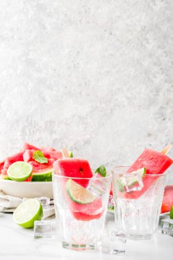 Dilimli karpuz ve nane, beyaz mermer zemin kopya alanı ile tatlı yaz karpuz ve kireç popsicles