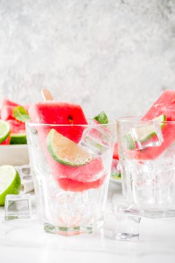 Dilimli karpuz ve nane, beyaz mermer zemin kopya alanı ile tatlı yaz karpuz ve kireç popsicles